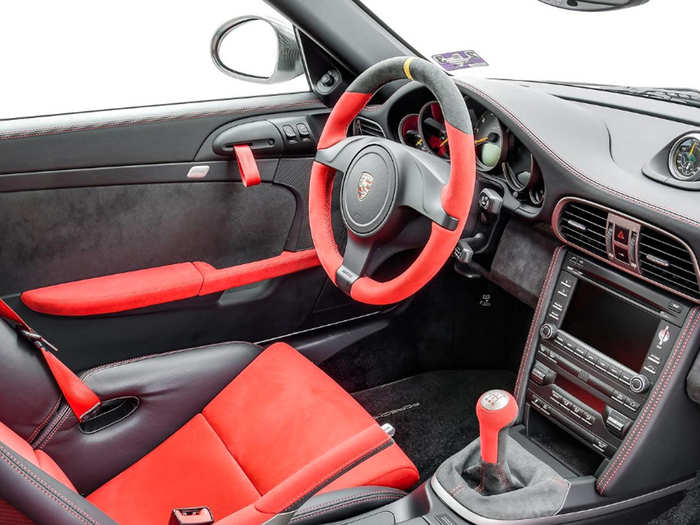 The interior has red accents and stitching.