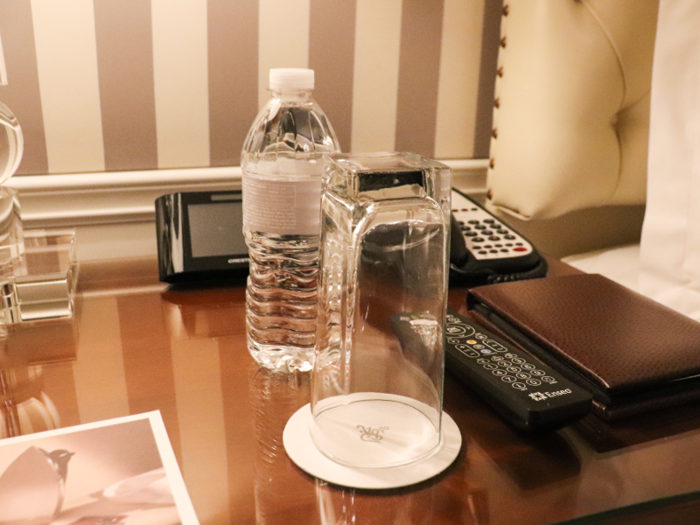 A bottle of water and a drinking glass were placed on each side table.