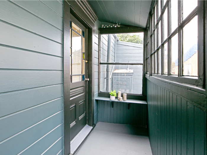 A small, partially enclosed porch is at the entrance.