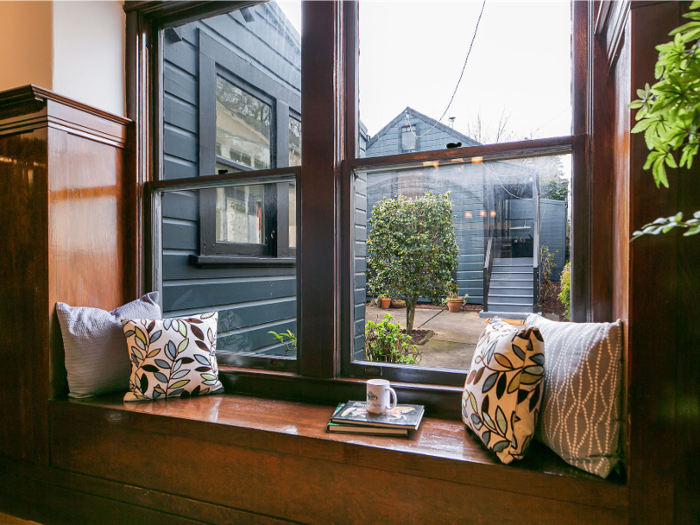 There are built-in cabinets and, ever so quaintly, a built-in bench by the window for a reading nook. The second home can be seen through the window.