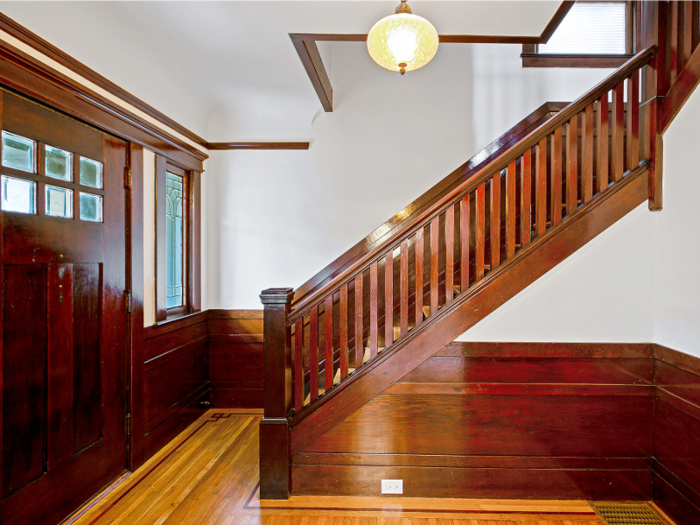 The foyer of the front home opens up to a wooden staircase leading to the second level ...