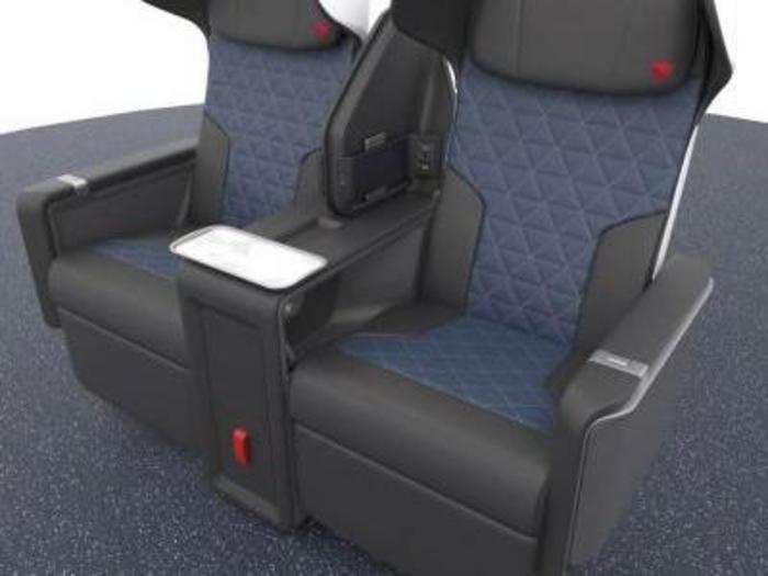 The seats feature larger tray tables — plus a larger tray between the two seats — memory-foam cushions, more power ports, and more storage space.