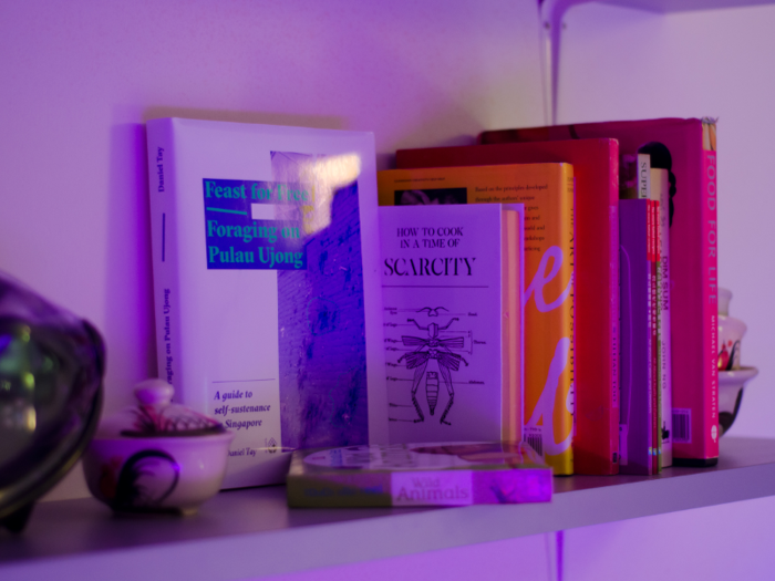 A bookshelf gives another peak into what life might be like, with titles like "How to Cook in a Time of Scarcity."