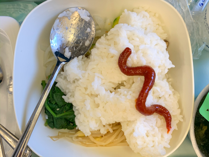 Passengers mixed their own bibimbap, combining vegetables and beef with a container of rice, a packet of sesame oil, and gochujang sauce.