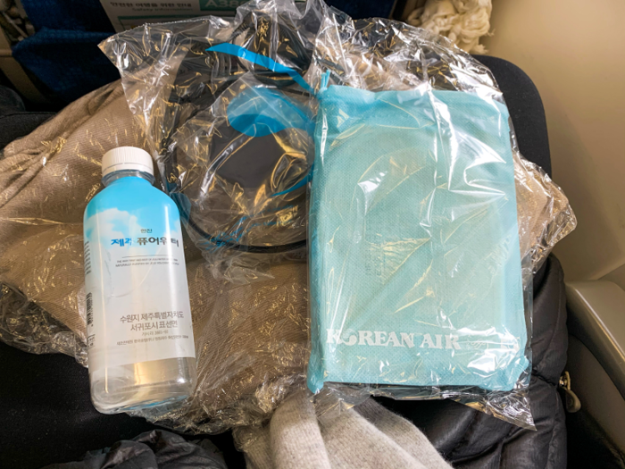 Korean Air supplies economy passengers with slippers, a blanket, headphones, water, toothpaste, and a toothbrush. The blanket was particularly impressive and thick.