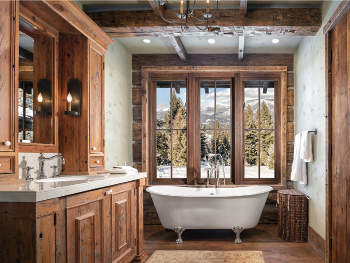 The home has 9.5 bathrooms. Listing photos show one bathroom with a clawfoot soaking tub with views of the mountains.