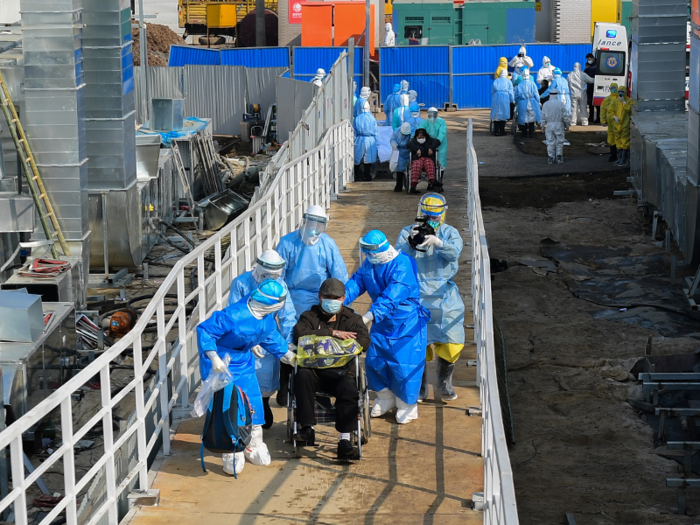 Images, obtained by the Associated Press, show medical staff in protective suits pushing people in wheelchairs up a makeshift ramp and into the pre-fabricated structure.