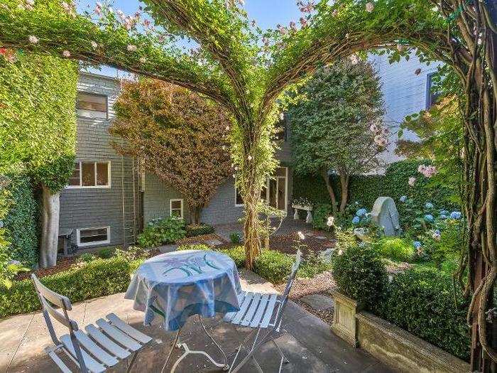 The sitting area surrounded by greenery is the perfect place for reading or enjoying a morning coffee.