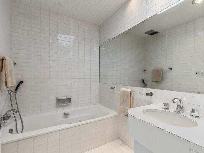 The tiled bathroom is spacious, with a shower and standalone tub.