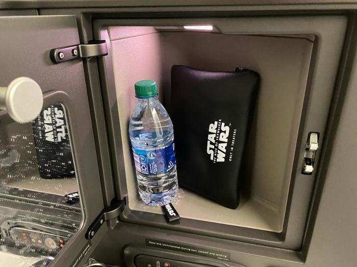 Waiting at my seat, in a nifty storage compartment, were a water bottle and a Star Wars promotional amenity kit.