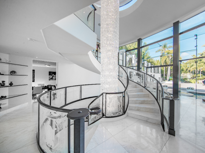 An 18-foot crystal chandelier sits in the center of a circular stairway.