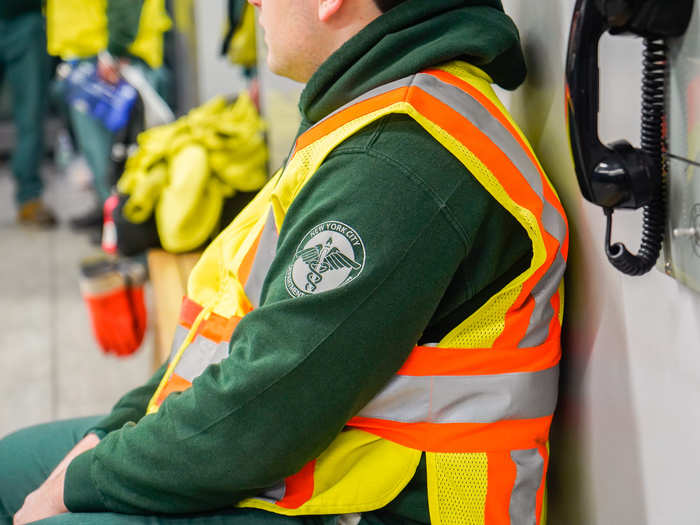 Sanitation workers — both collectors and supervisors — wear different shades of dark green uniforms with a reflective vest on top.
