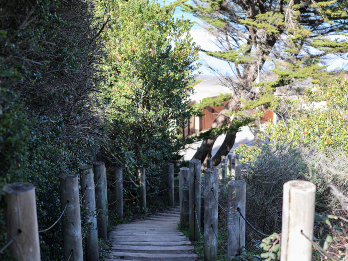 A winding staircase leads down from the street level to the beach.