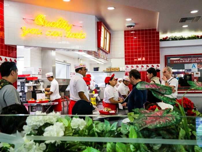 In-N-Out is cheery inside, with bright tiles, vibrant fake plants, and neon signs.