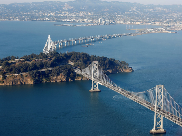 The island is a naturally-formed landmass that sits between Oakland and San Francisco. The Bay Bridge crosses through it.