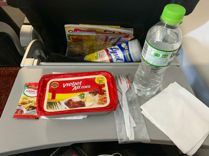 Flight attendants, who were zooming down the aisle with impressive efficiency, dropped off my meal in some brightly colored packaging.