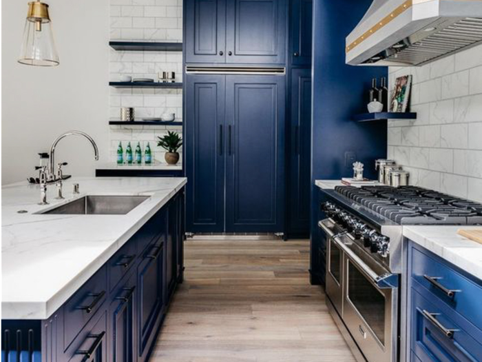 The kitchen boasts deep midnight blue cabinetry.