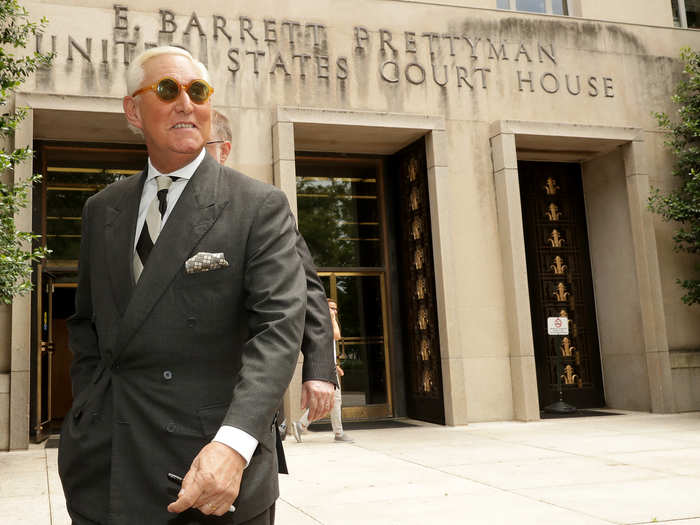 Stone poses for the cameras after he is seen walking out of the courthouse.