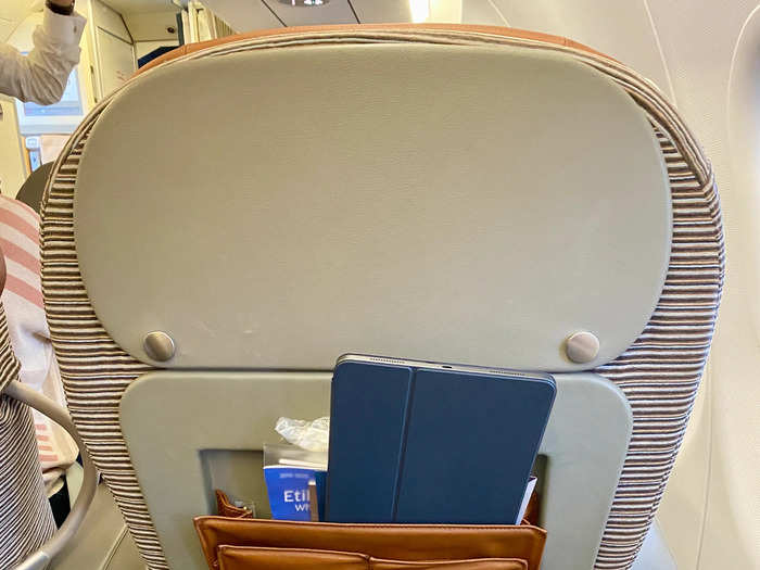 Because the seat in front of you is so far away, the in-flight entertainment screen is mounted onto a swinging arm that tucks away in your armrest.