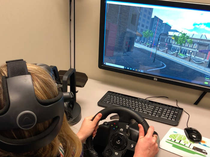 After reviewing practice footage, I sat down for some virtual reality training. I wore a headset and drove down city streets practicing UPS