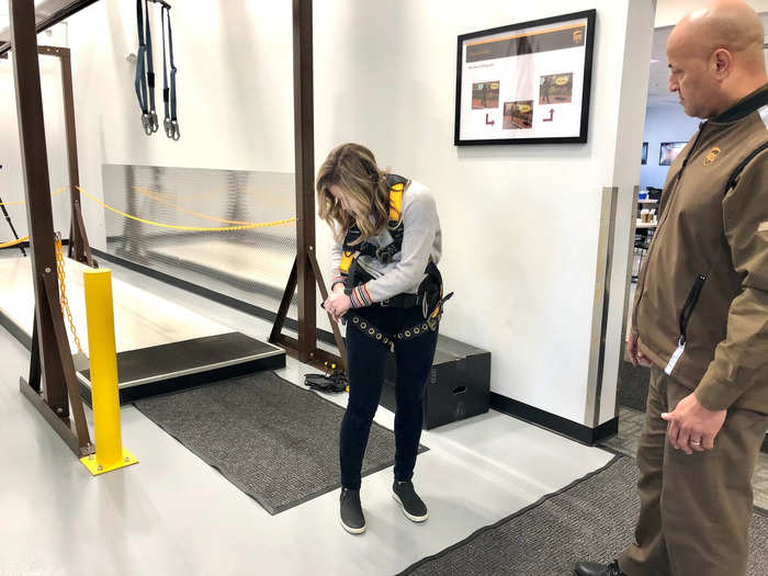 Before checking out the trucks, we stopped at a "slip-and-fall" station, where UPS drivers learn how to safely walk on ice. I strapped into a harness to test out the machine.