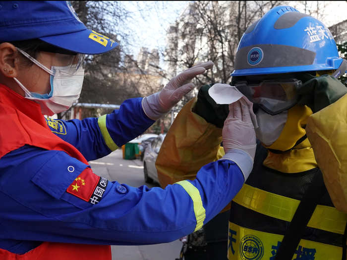 Another volunteer, Huang Jun, helped her husband by wiping disinfectant off his mask.