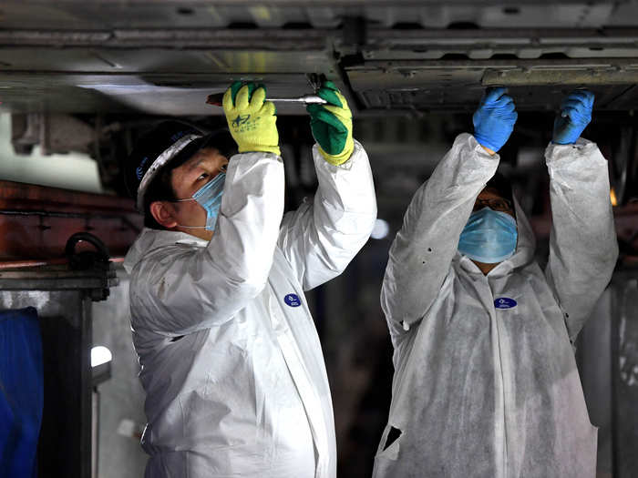 Maintenance workers disassemble the air conditioning evaporator to ensure clean airflow.