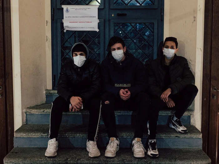 Public buildings are also closed. Here, three masked boys sit in front of a poster explaining the closure. They don