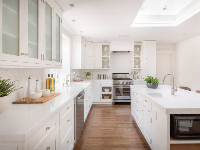 The kitchen continues the white palette, with quartz countertops and a large island with plenty of storage.