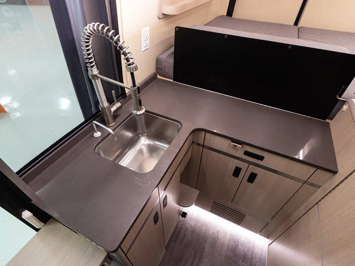 The kitchen area has a steam convection oven, sink, and espresso machine.