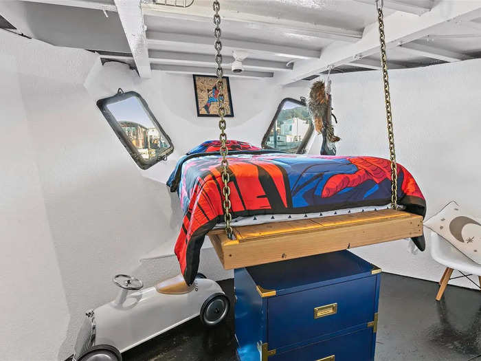 The room maximizes lateral space with a unique bed, which is suspended from the ceiling.