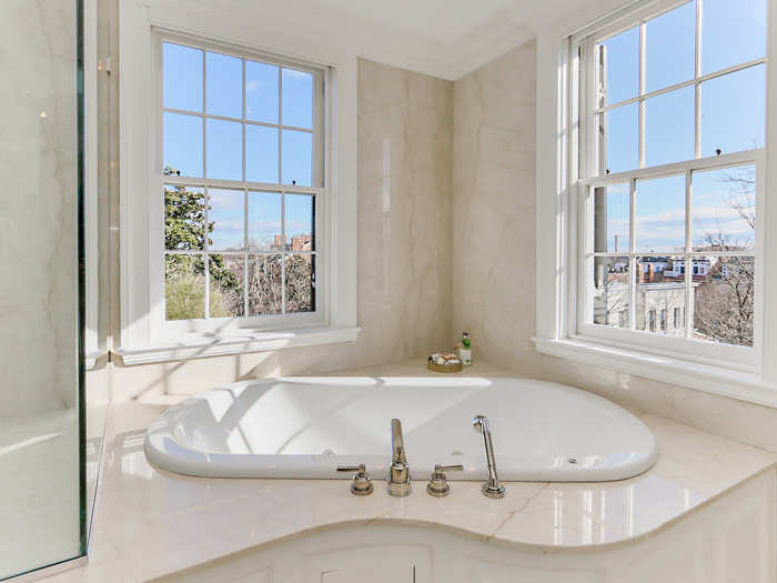 The master bathroom features a large soaking tub, a rain shower, and heated floors.