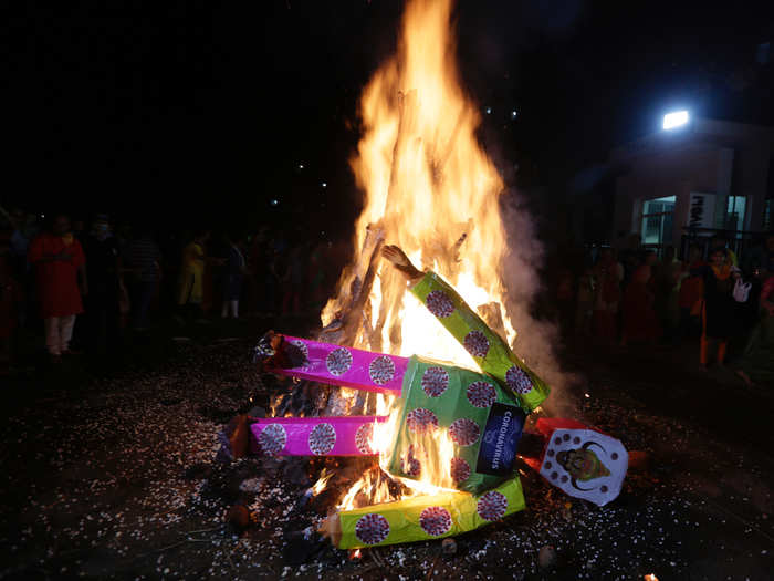 In Ahmedabad, India, devotees went another route, dressing up the coronavirus in pink and green. Both effigies met the same fiery fate.