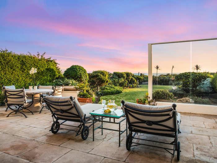 A patio overlooks the lawn toward the ocean.