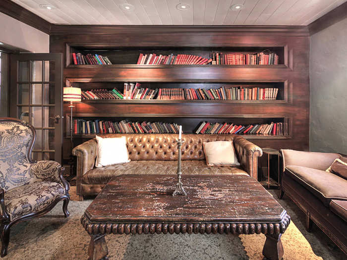 A room styled like a library is finished in dark wood.