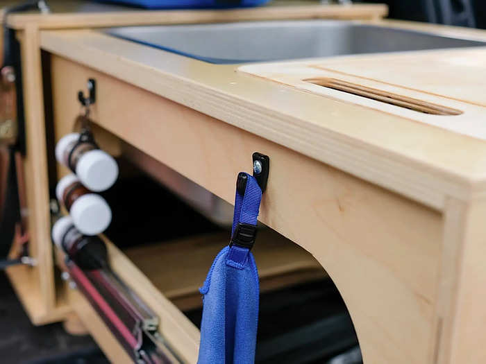 There are hooks around the extended kitchen to hang different cooking accessories, such as a spice rack and trash bags.