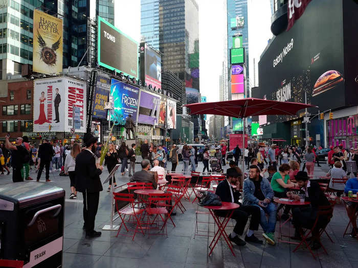 BEFORE: In 2018, many people sat and rested on red chairs in Times Square. There were few spare tables.