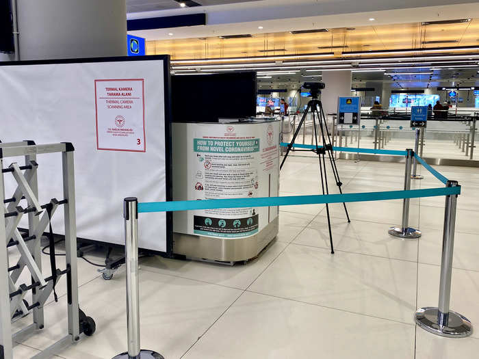 There were signs of COVID-19 precautions everywhere, including temperature screening stations all throughout the arrivals hall — there was a person behind this booth watching a monitor, which was connected to the thermal camera on the tripod.