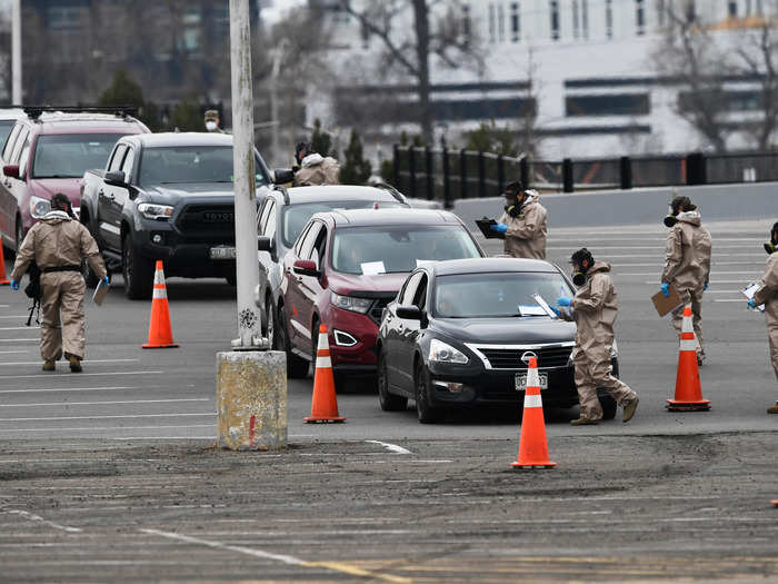 Here, cars line up to await instructions from healthcare workers at a testing site in Denver.