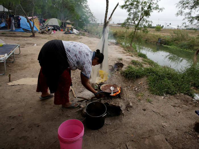 With no electricity or running water, the conditions in the camp are dire. This woman in the camp is cooking beans on a self-made fire.