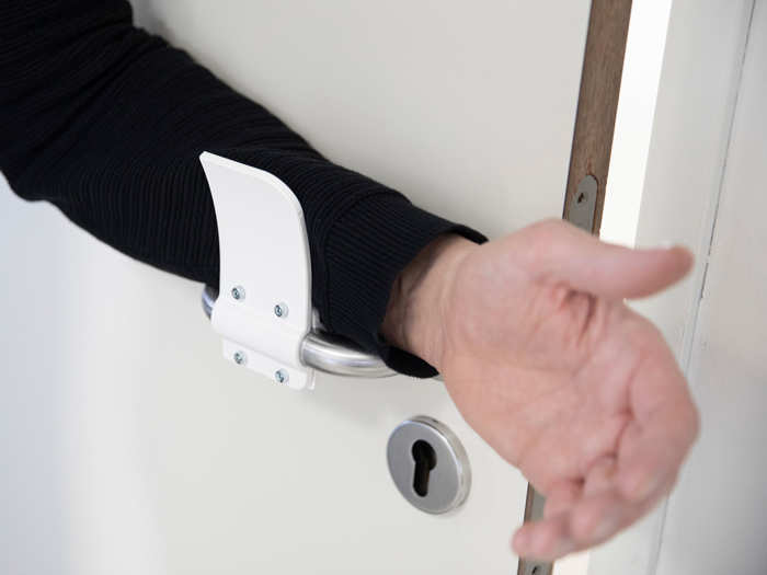 The shape of the new door handle allows people to open doors with their arms, avoiding directly touching with their hands.