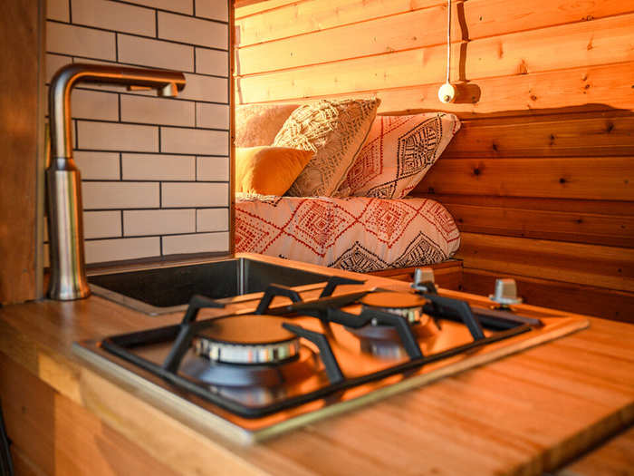 The kitchenette has a two-burner stove top with a sink and counter space for food preparation.