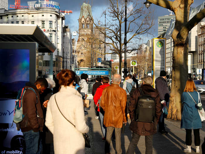 BEFORE: People can be seen waiting at a bus stop on the Kurfürstendamm, Berlin