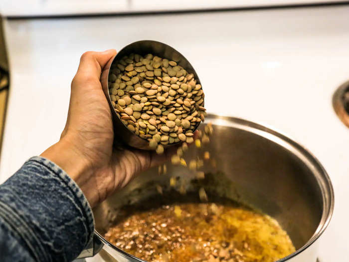 Once your spices are lightly toasted, add your lentils. You can sort and rinse them first if you