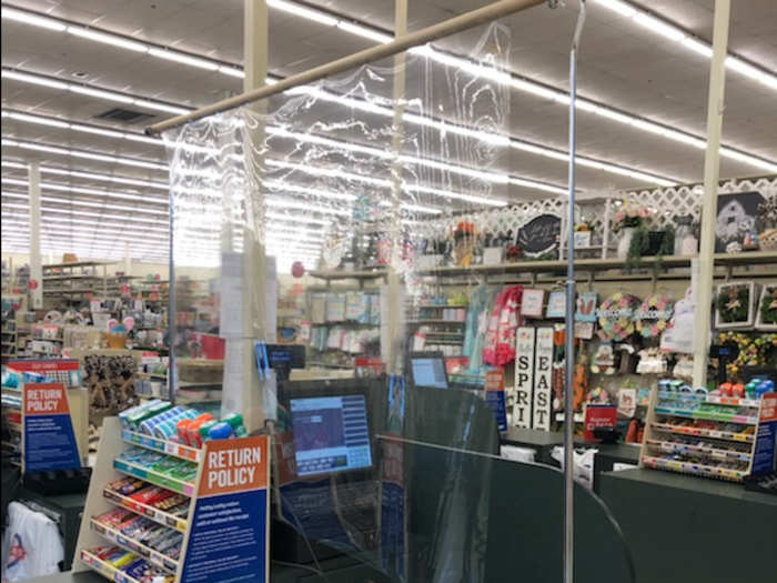 Thin and flimsy "sneeze guards" have been placed at registers, offering minimal barriers between customers and sales associates.