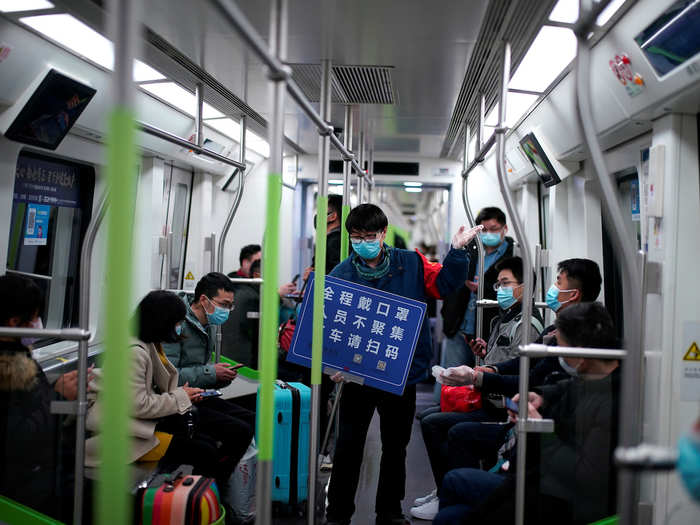 People are constantly reminded that in order to get around, they must show their codes. Here, a staff member on a Wuhan subway is holding a sign that reads: "Always wear a face mask, avoid gatherings, scan code when getting off the train."
