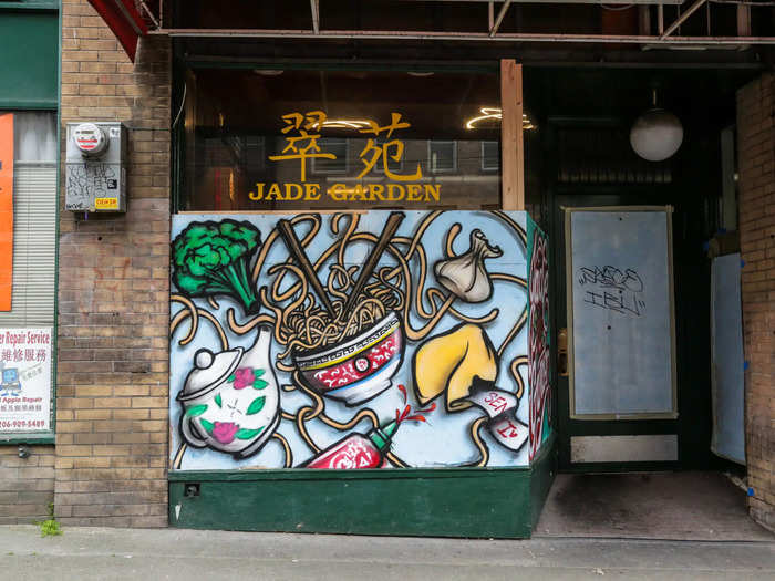 The artists painted murals on all the window boards, depicting the food still being cooked up by Chan