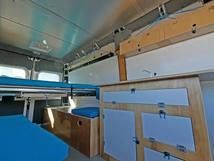 The "Walter" kit for the 136-inch wheelbase has similar amenities as the "Wally", but with more features and structure. The "Wally" kit comes with a pull-out table, three-piece flooring, insulation paneling, shelves, a storage box, a standalone bed platform, and a kitchen with water tanks and a sink.