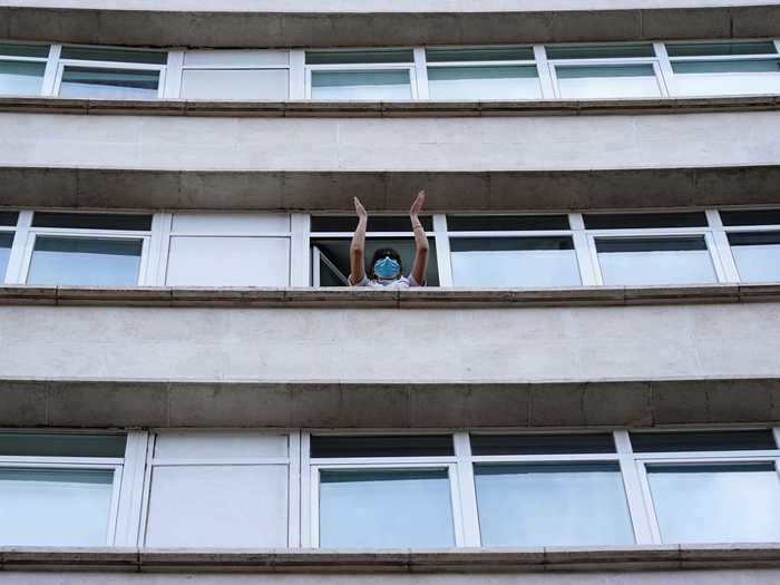 A single medical worker joins in on the applause in Madrid, Spain.