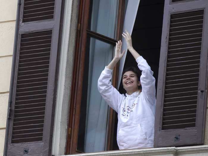 A woman claps in Milan, Italy.